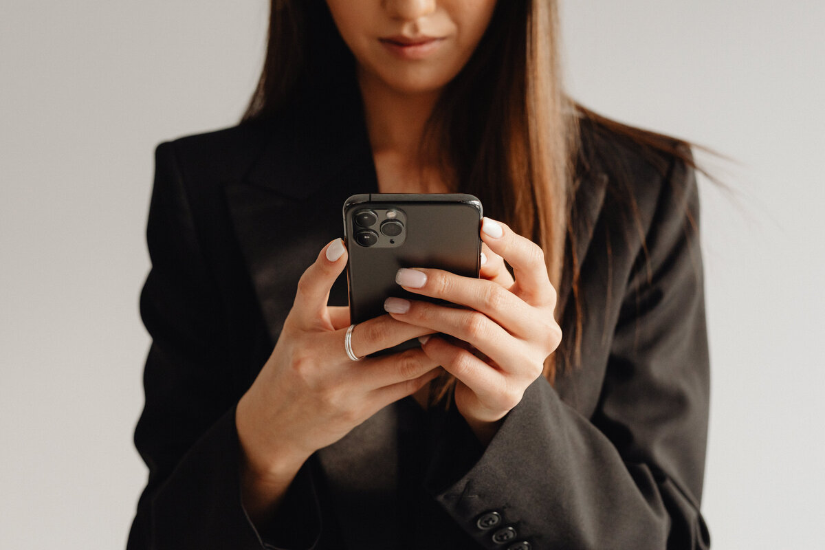 kaboompics_dark-classy-aesthetic-fashion-beautiful-asian-female-entrepreneur-in-black-suit-technology-and-devices-iphone-laptop-airpods-30090
