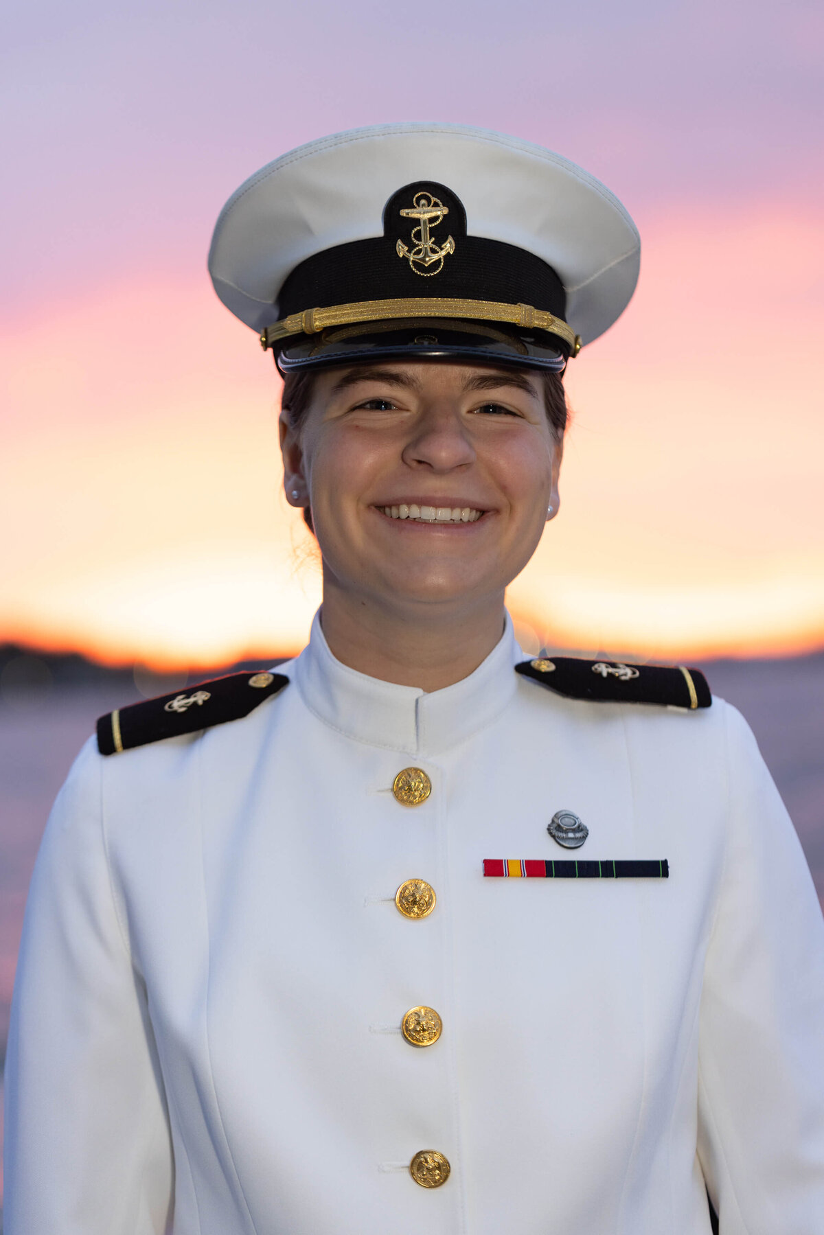 Beautiful, smiling navy officer in white uniform at sunrise in Annapolis Maryland.