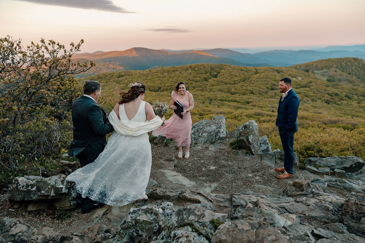 A dad walks her daughter to her ceremony spot at Stony Man in Shenandoah. Her groom and college friend officiant are waiting for them