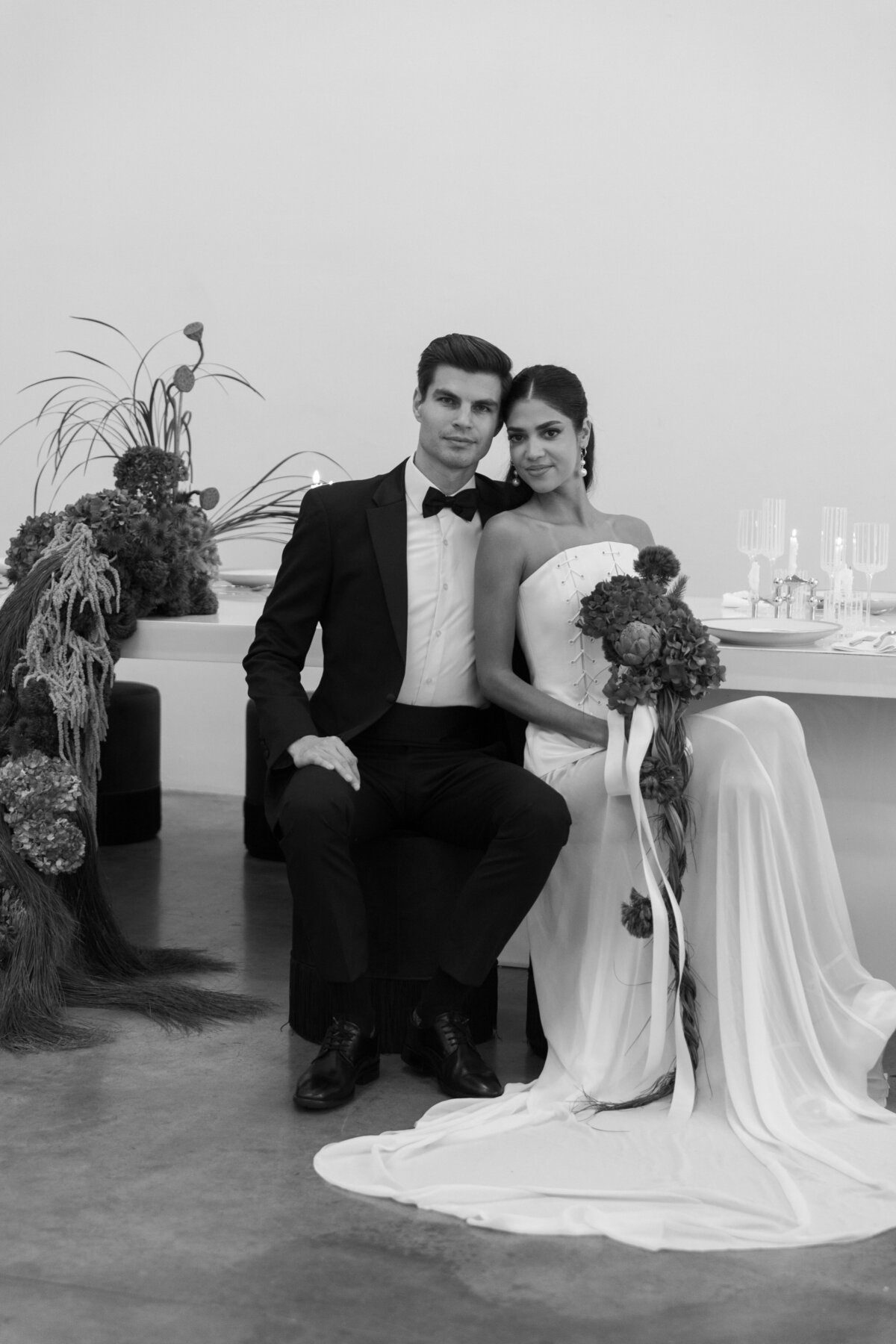 Modern wedding reception table featuring cascading blue hydrangeas, greenery, and tall sculptural florals at a New York City studio.