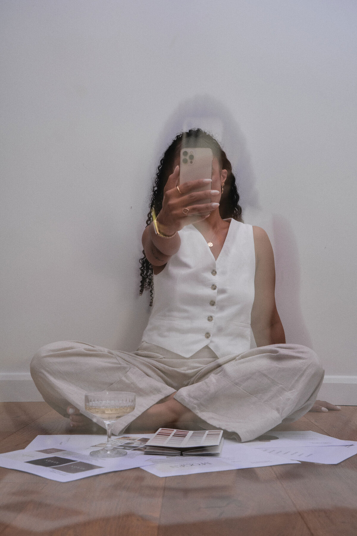 Woman sat on the floor holding a phone in front of her face