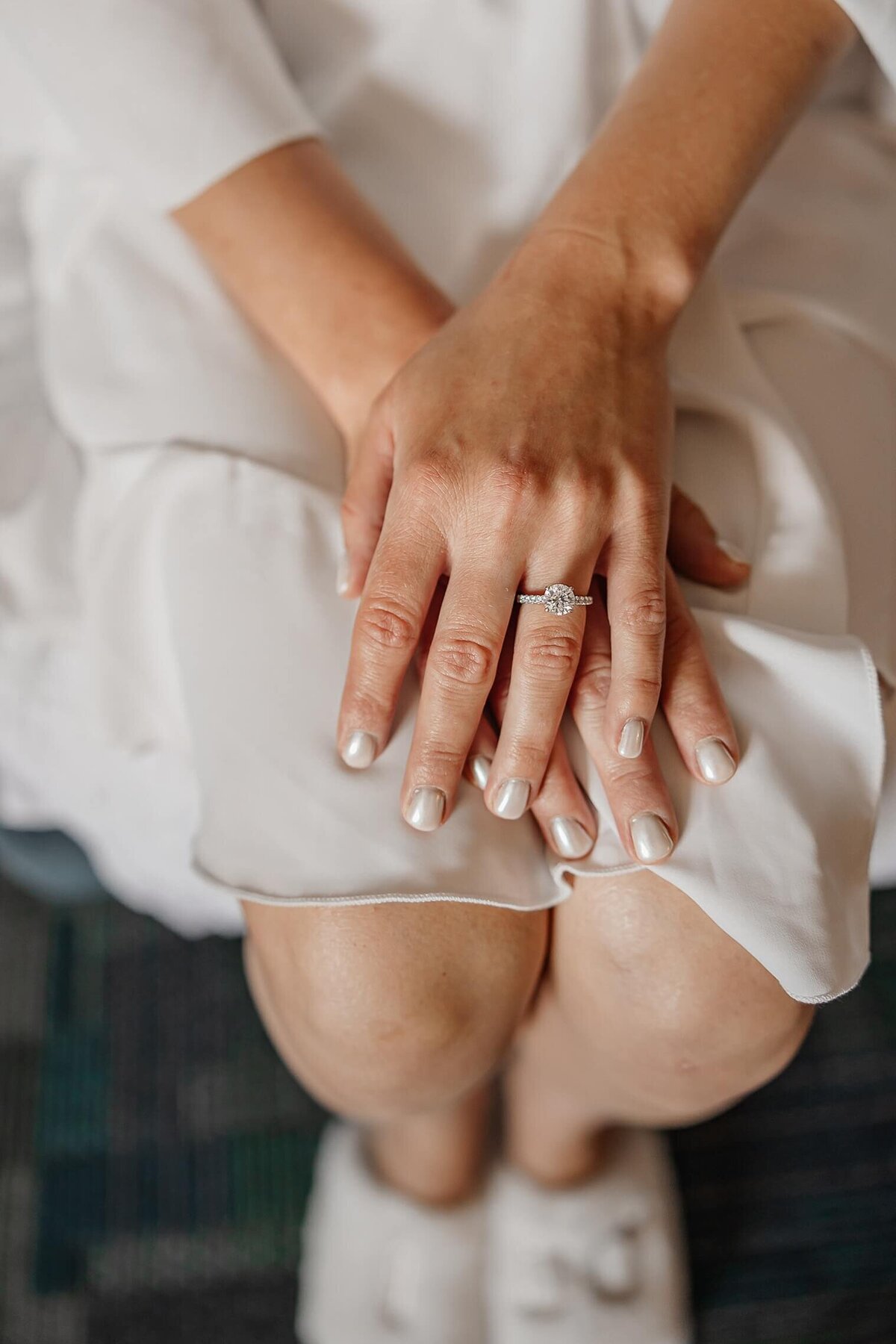 Wedding detail photograph of hands and her engagement ring
