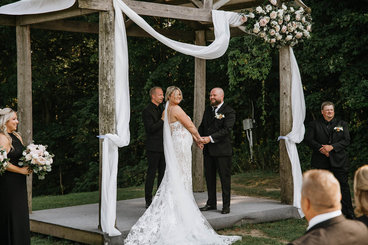 Bride-and-groom-holding-hands-at-alter