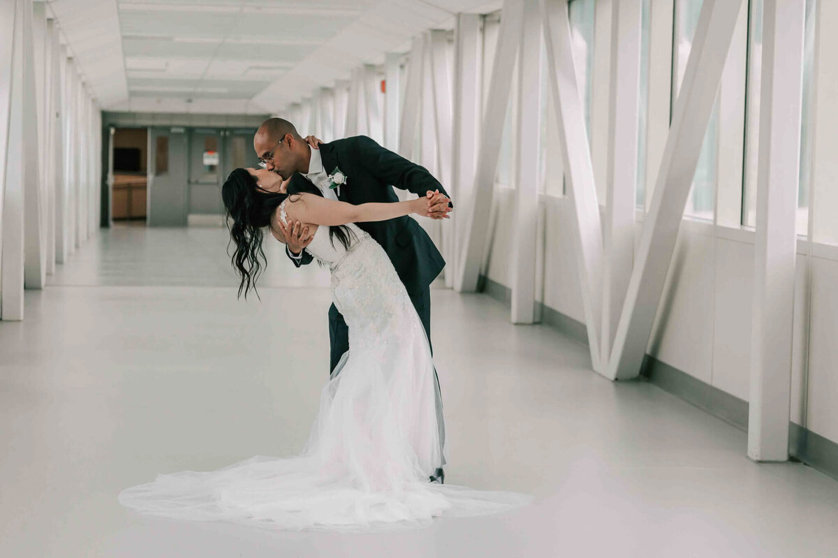 Groom has bride in a dip and kissing her.