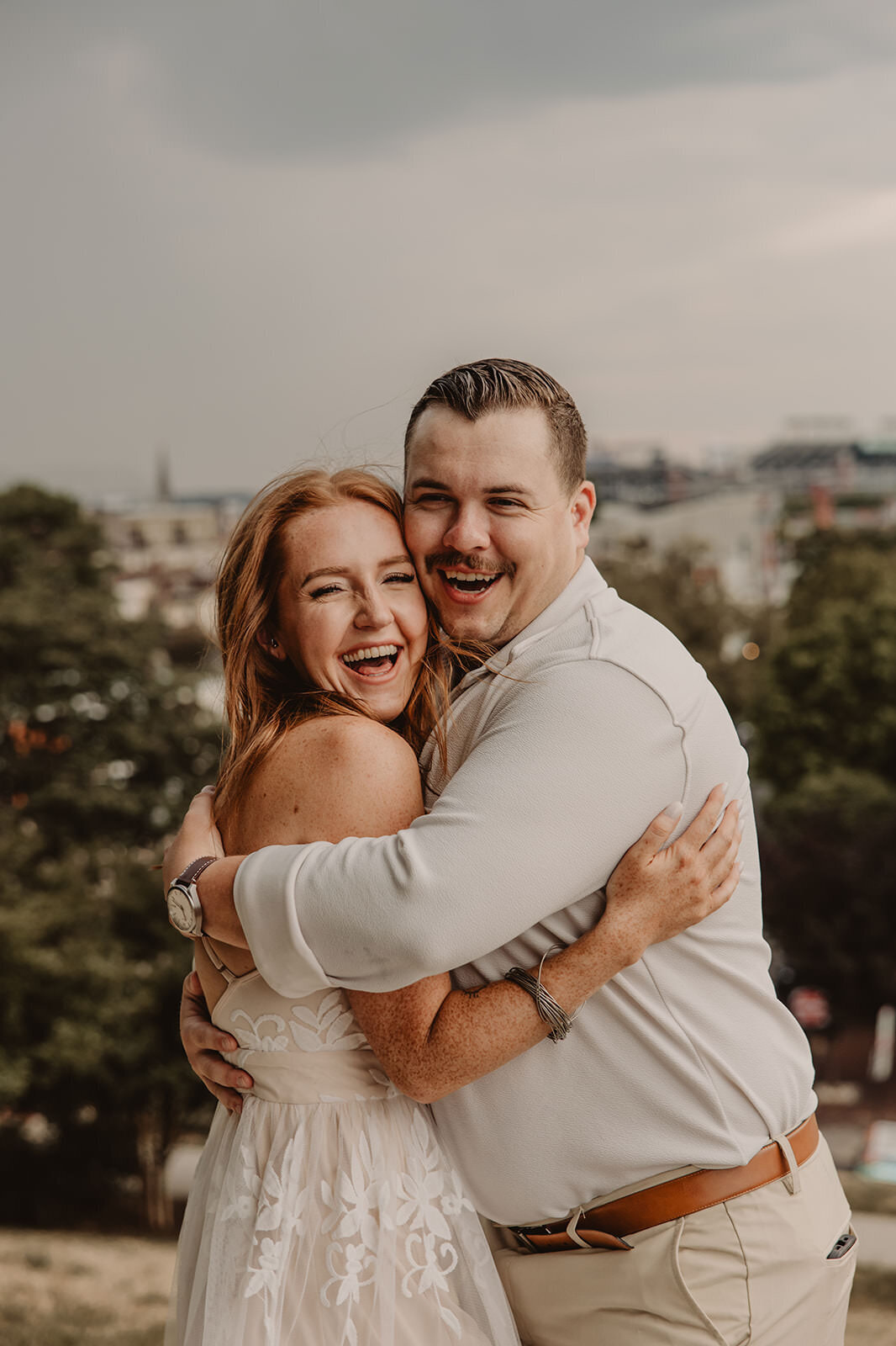 A coupe hugging tightly as they smile 