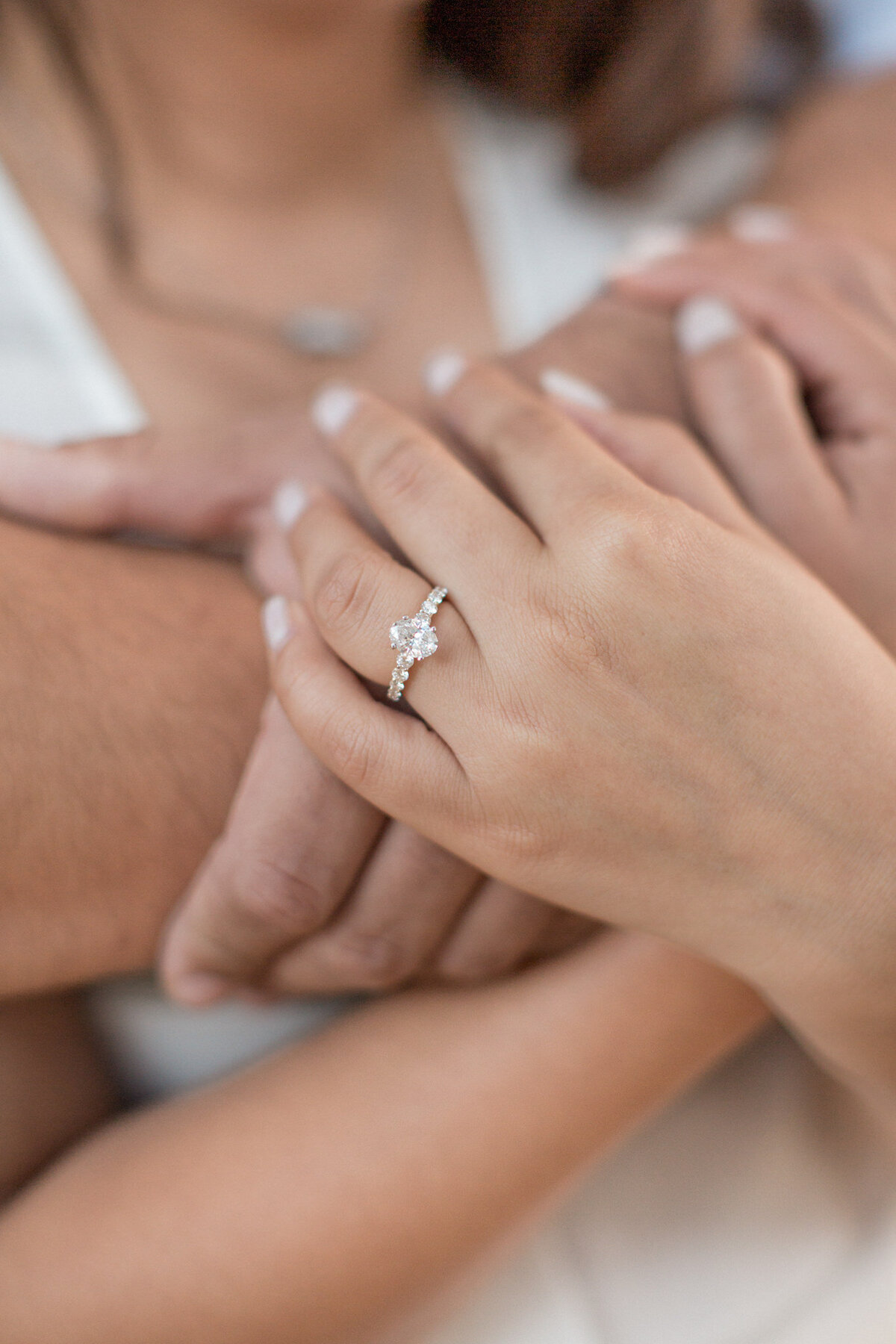A close up of the engagement ring  on a woman's hand