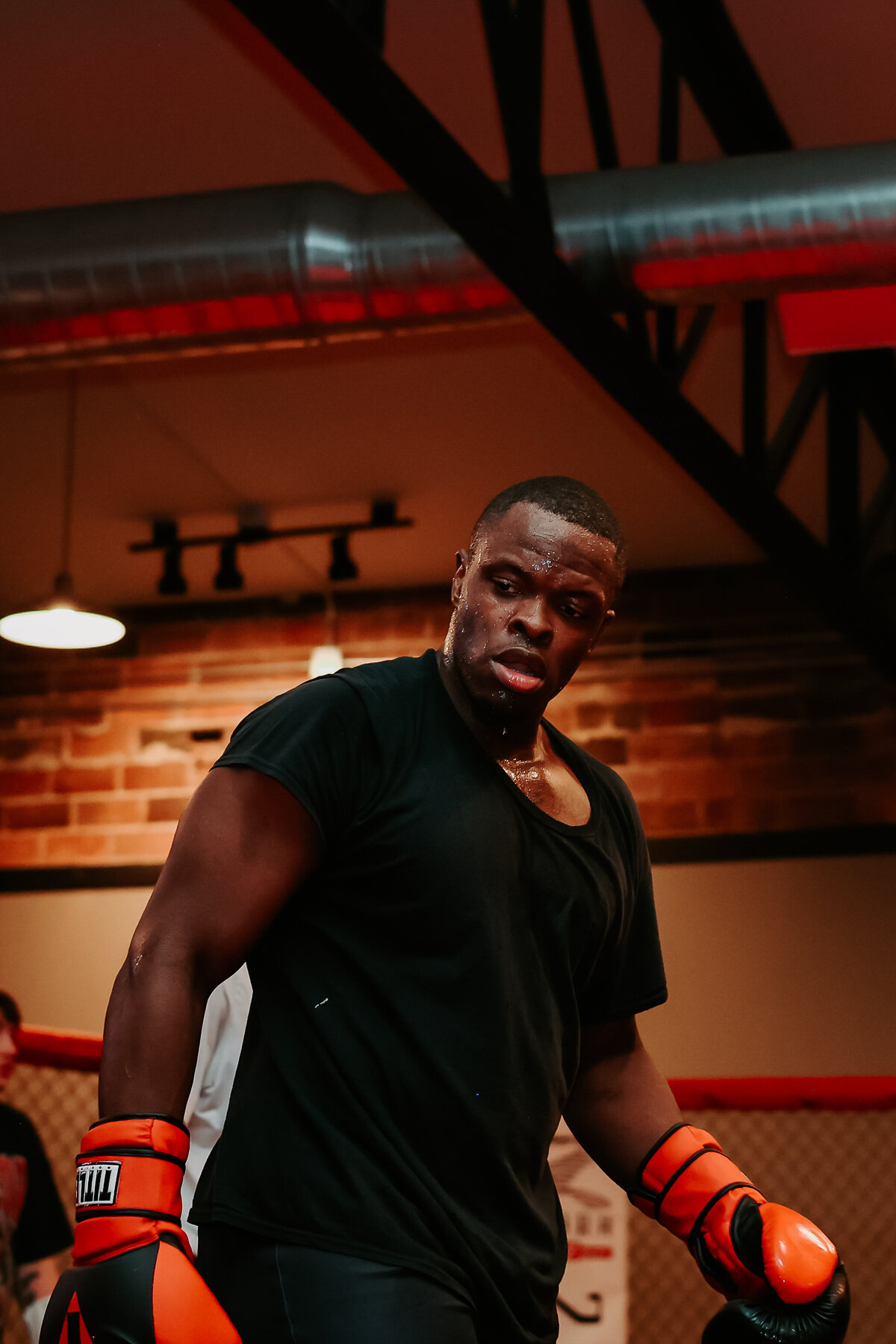 A person standing in a gym with boxing gloves on