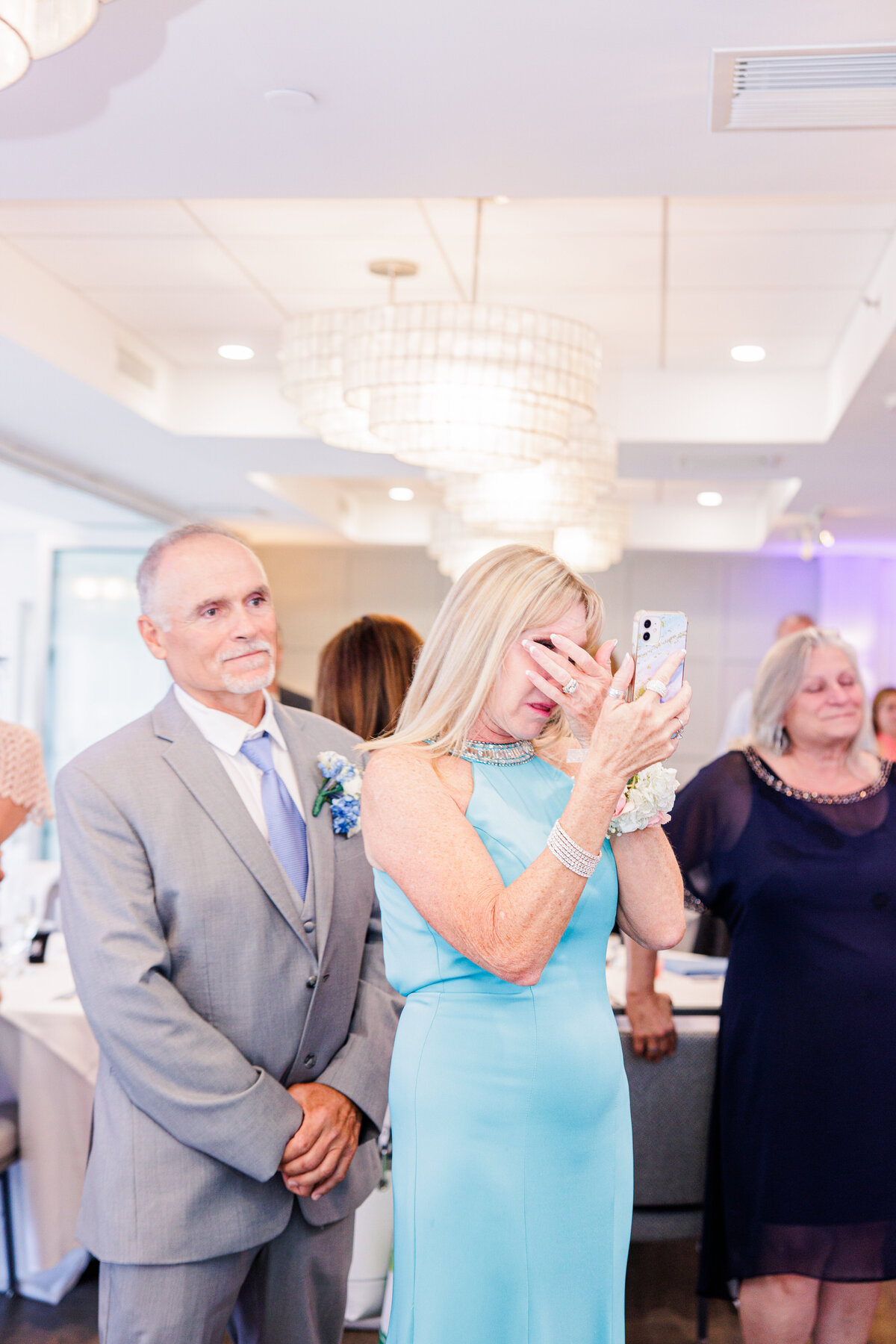 A mother of the groom tearing up watching the first dance representing candid Cape Cod wedding photography