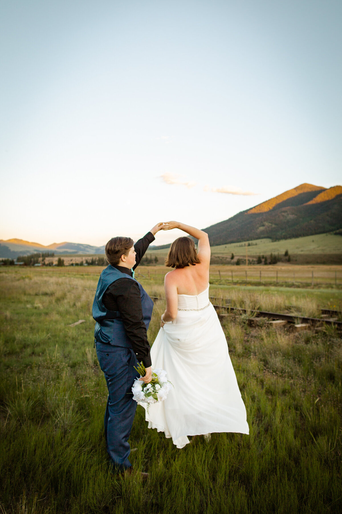 Couple spins in an open field during their wedding day