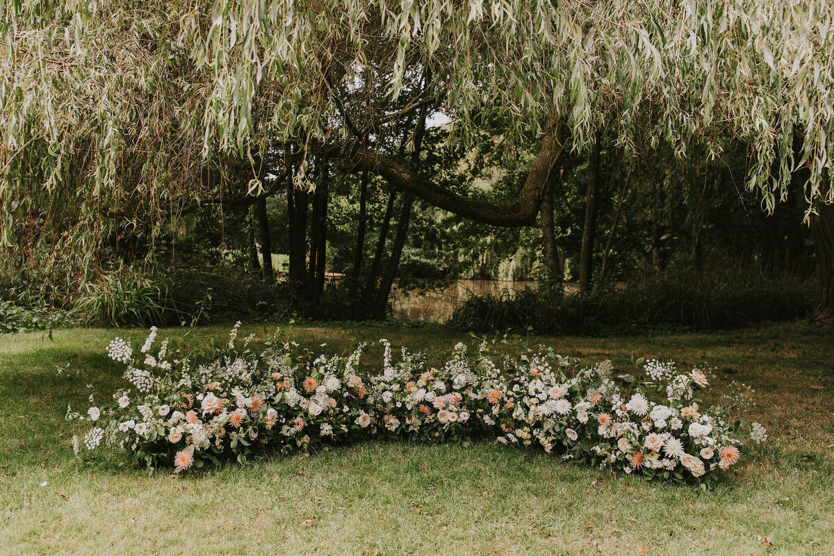 Outdoor ceremony flowers at Dewsall Court. Semi circle meadow of flowers