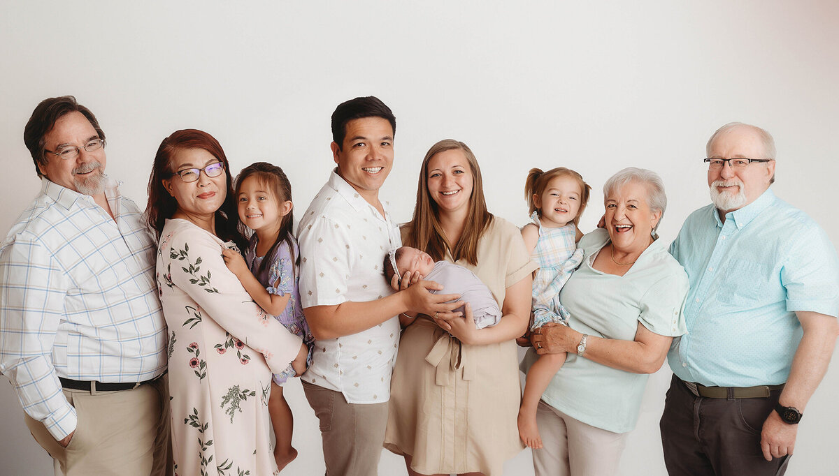 Family embraces their infant during Newborn Portrait Session in Charleston, SC Newborn Photography Studio.