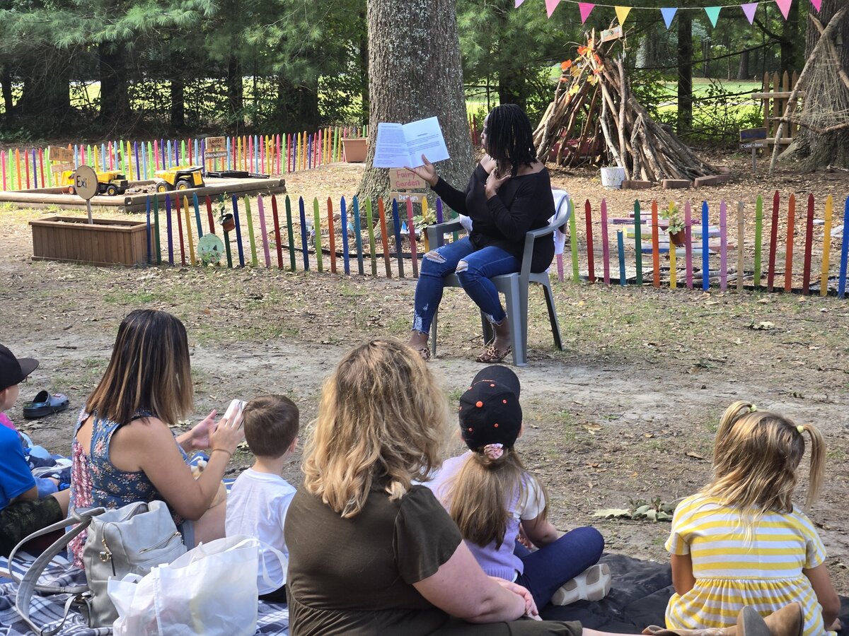 Preschoolers gathered outdoors for story time at ROOTS