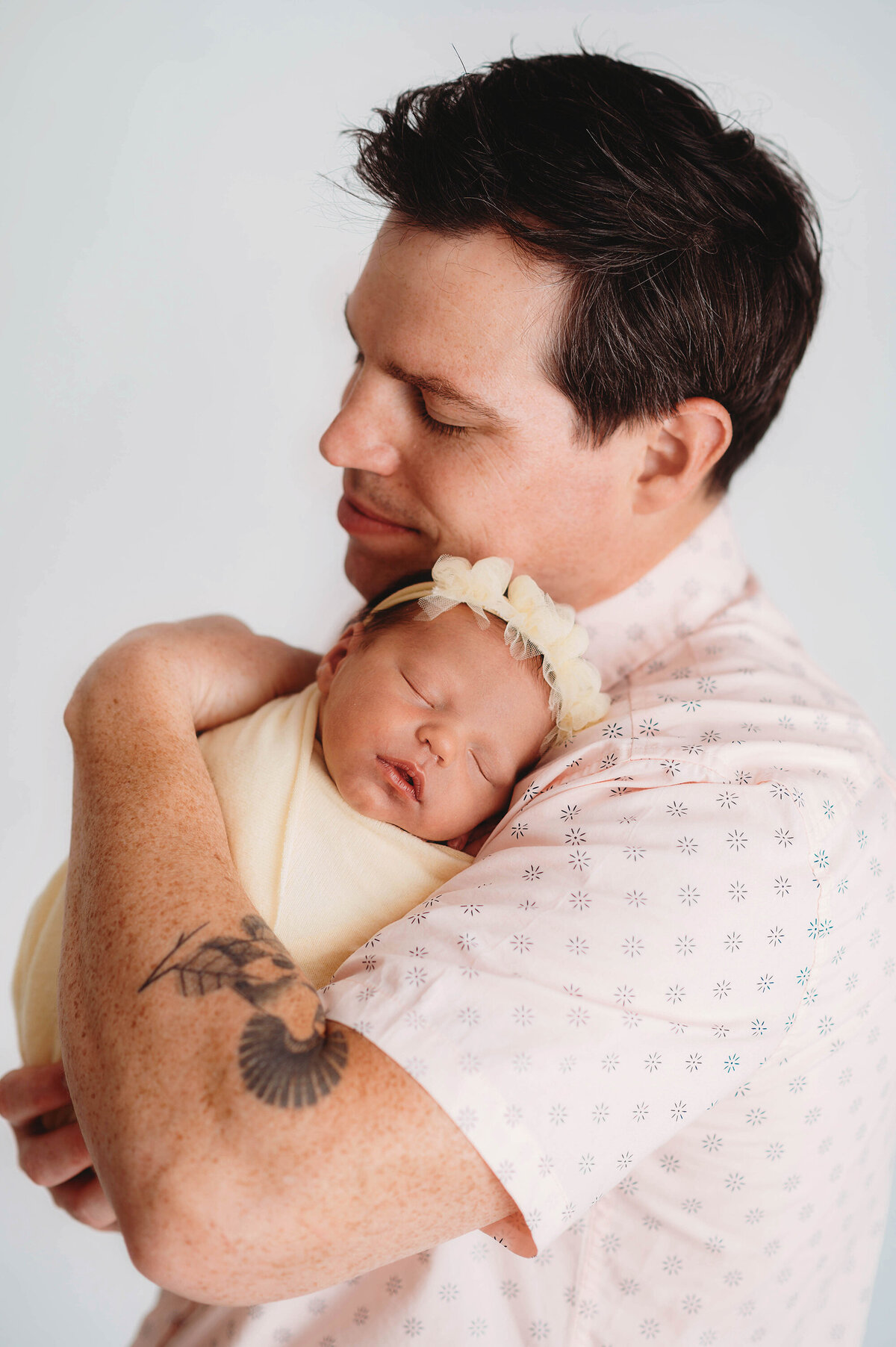 Father embraces his newborn daughter during photoshoot in Asheville.