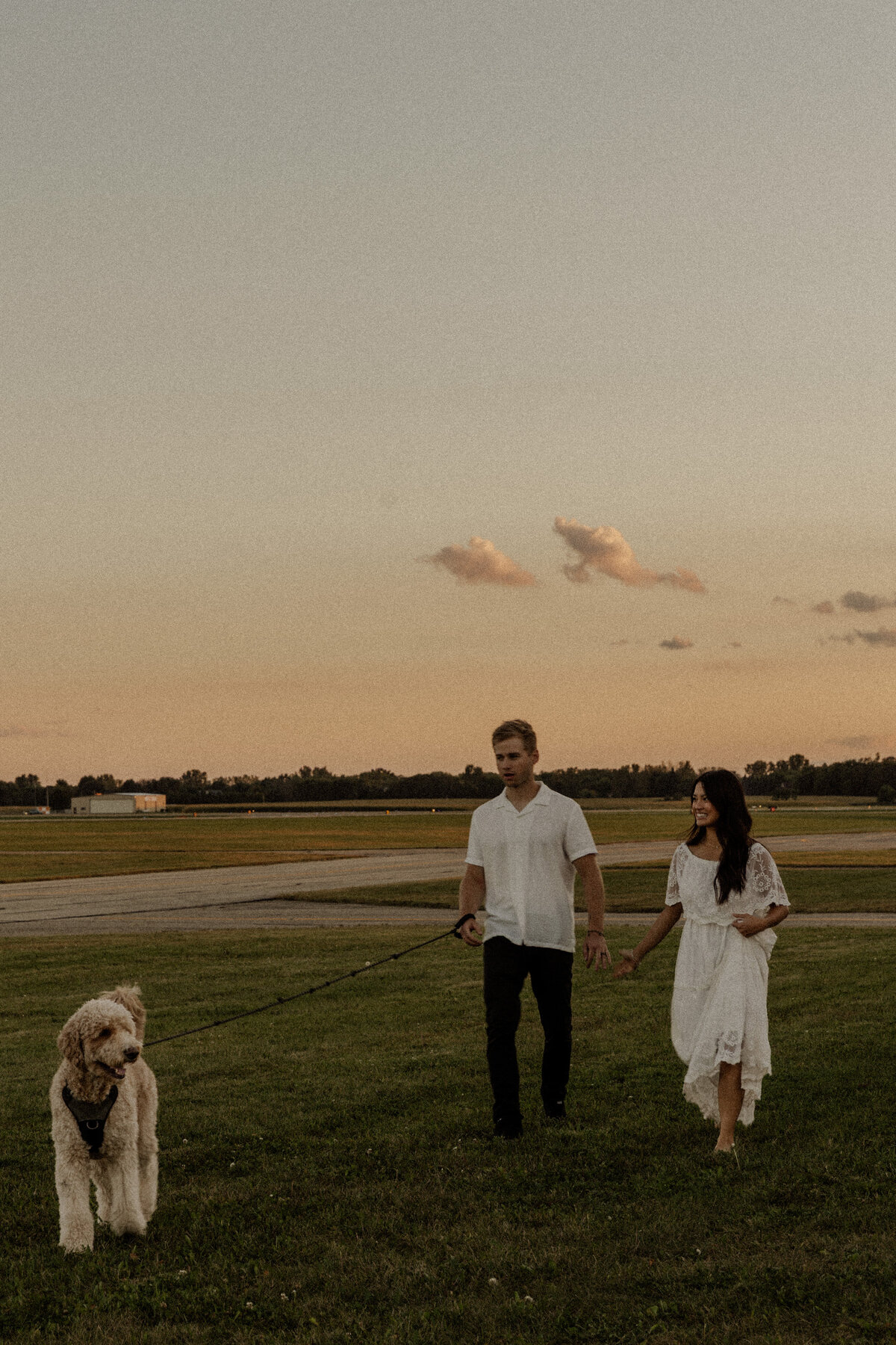 Engagement Couple Walking with their dog at sunset captured by a MN Travel Photographer 