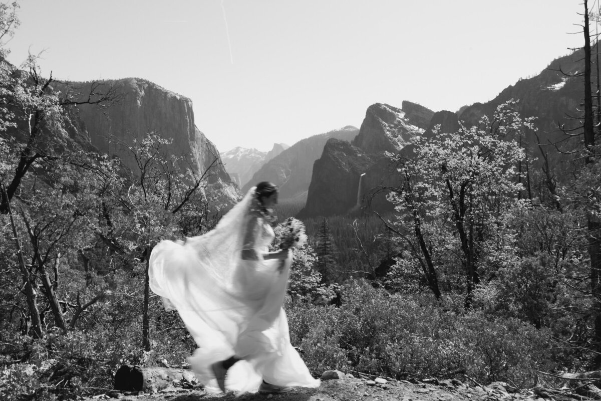 Bride walking alone on forest trail during Yosemite elopementokkddch