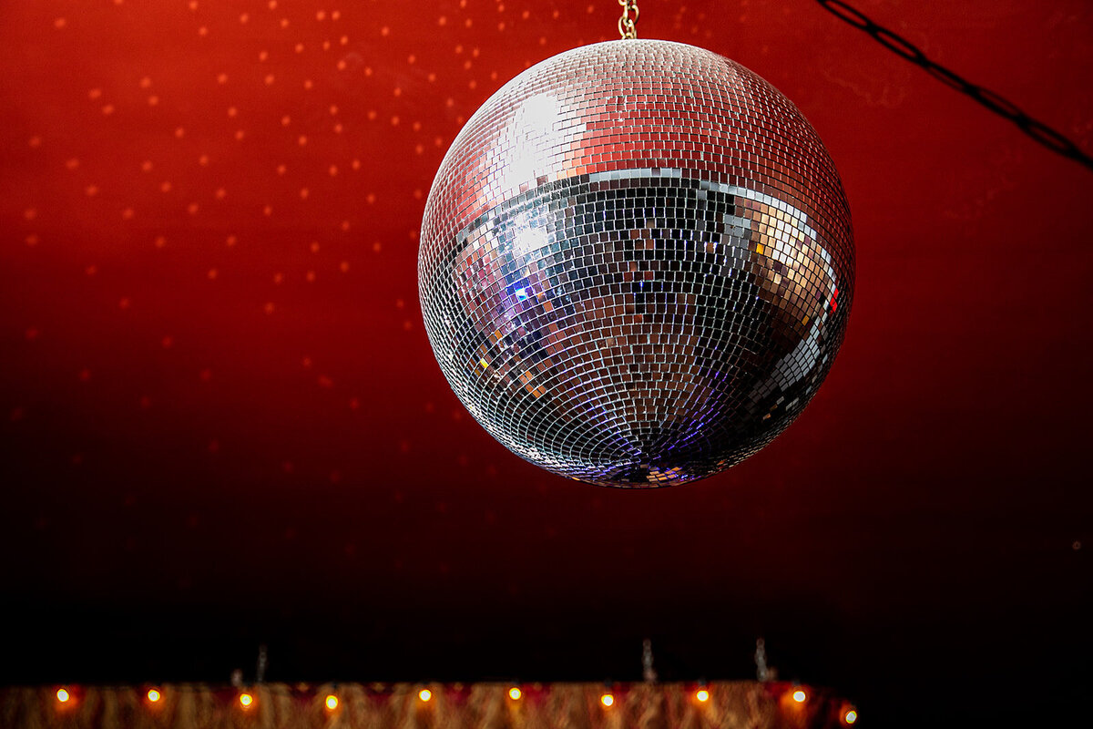 Close-up of a disco ball under red lighting.