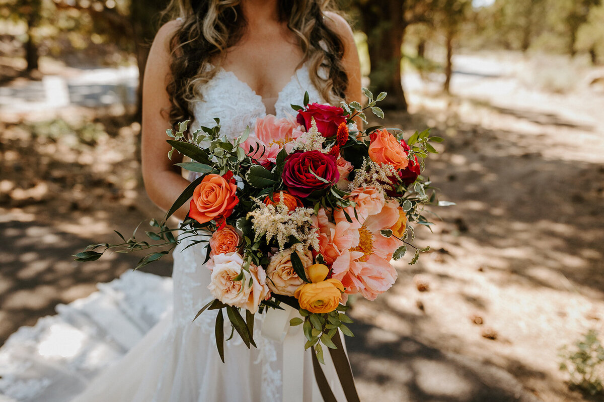 Bright mixed wedding bouquet with coral, orange and blush flowers
