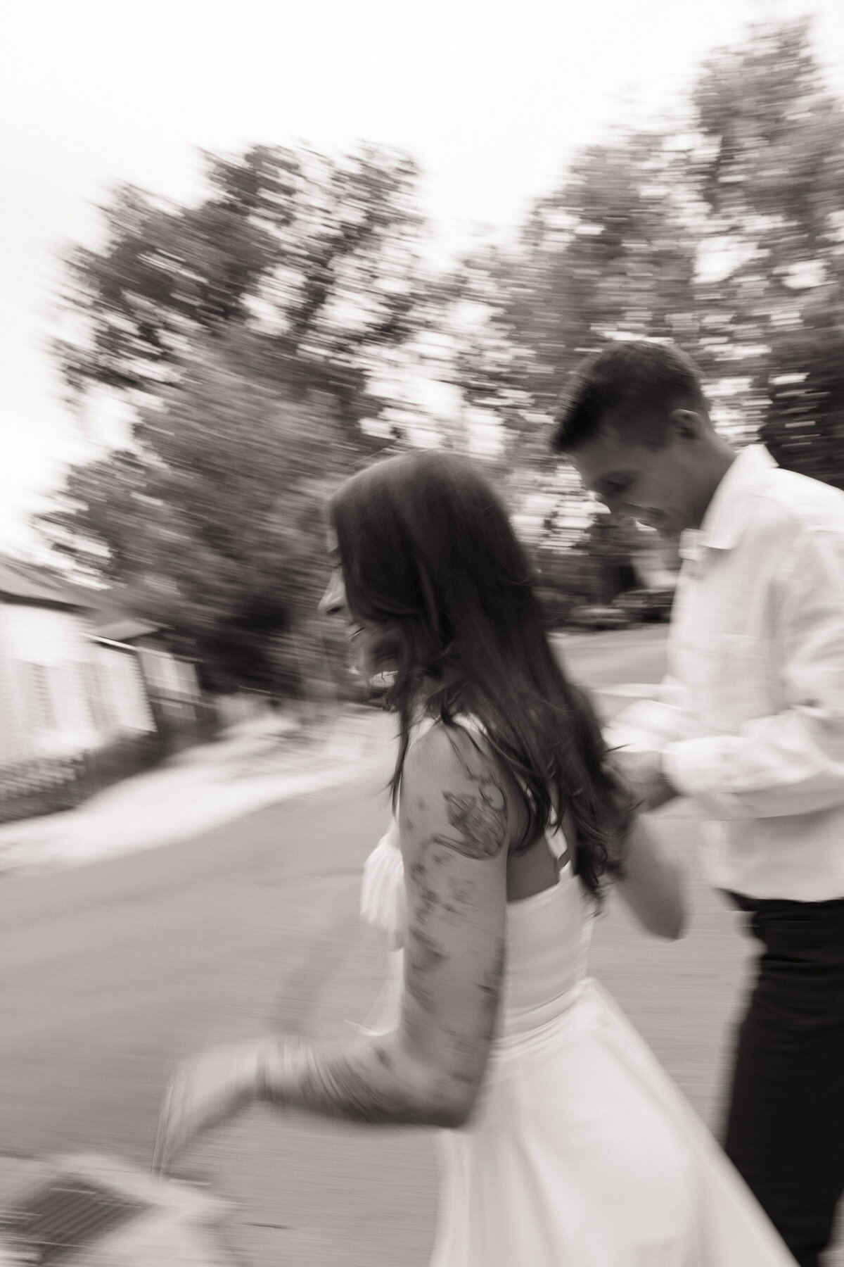 Playful photo of couple running hand-in-hand during engagement session in downtown Boise, Idaho