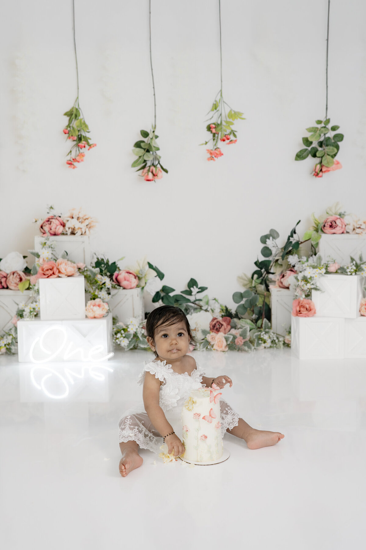 Girl eating cake during floral themed cake smash session— captured by Alliston and Barrie cake smash photographer.