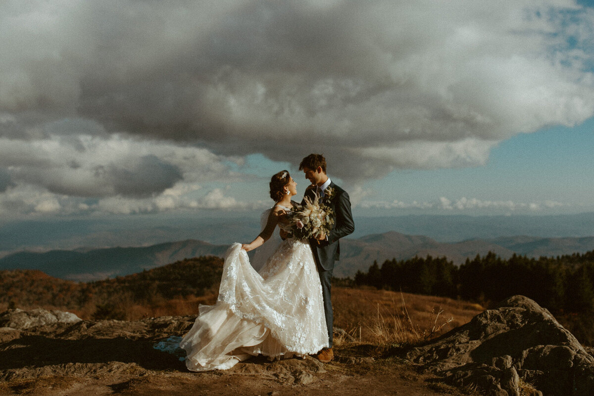 man and women embrace on mountain at golden hour