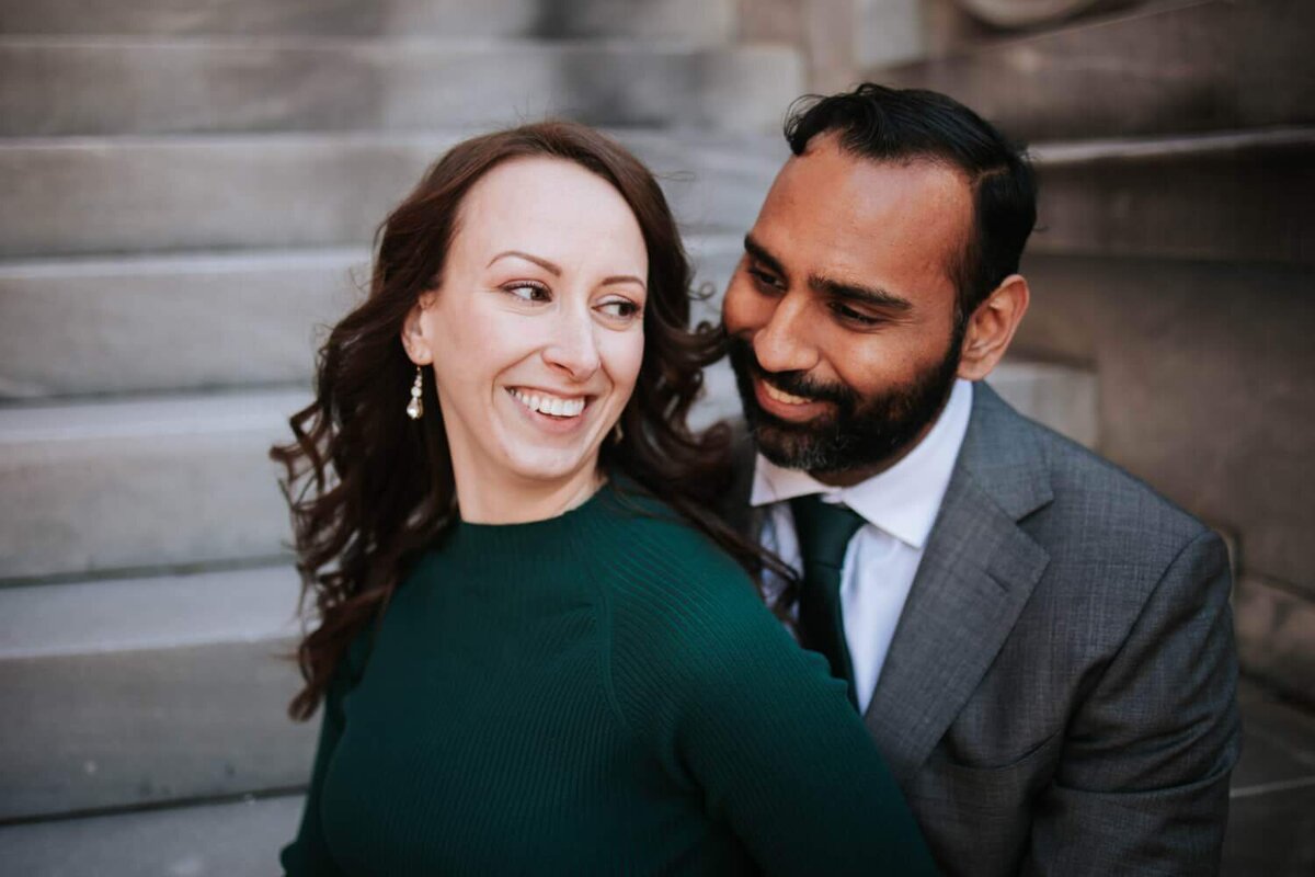 Couple standing on stairs hugging during engagement session in Philadelphia.