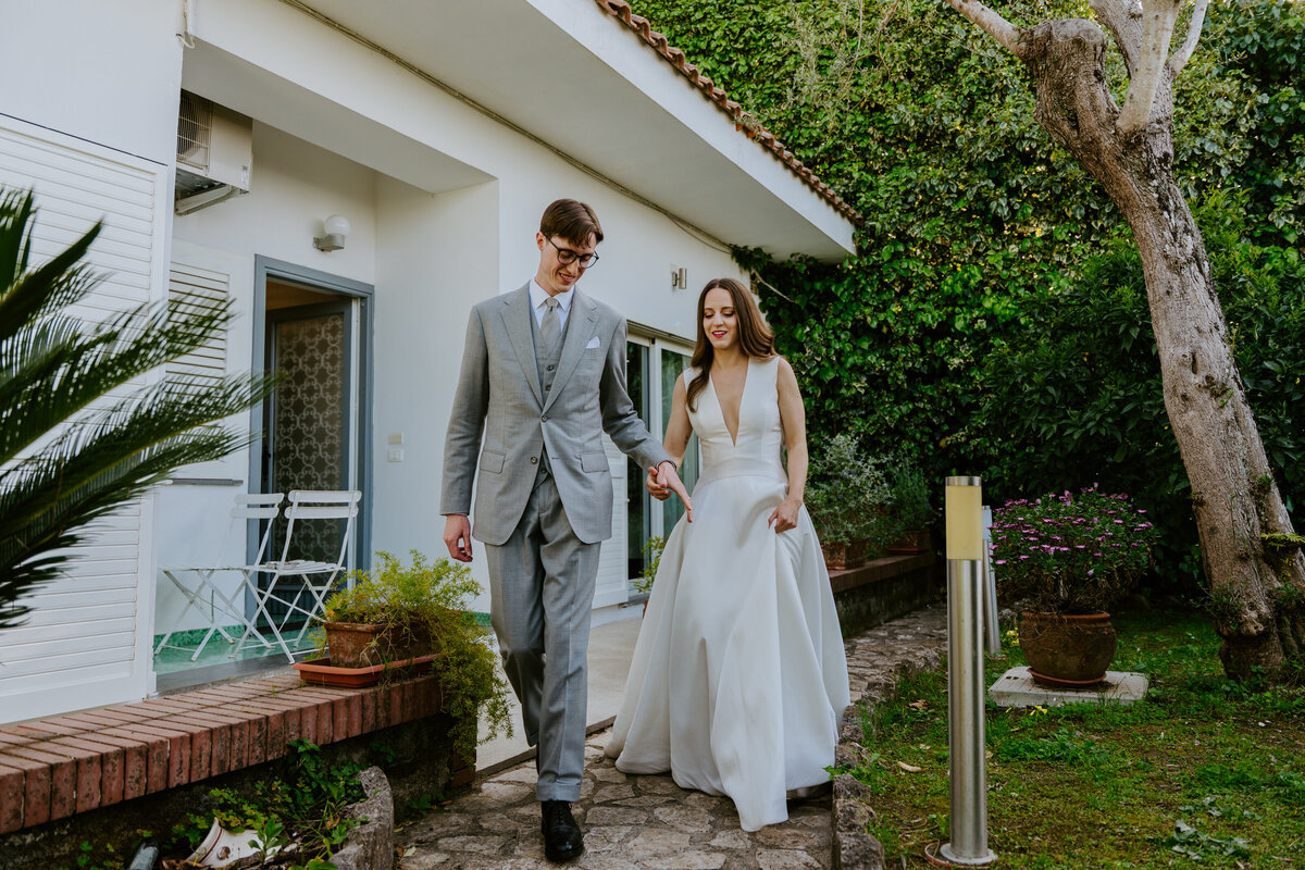 Bride and groom walking together through villa garden in Sorrento