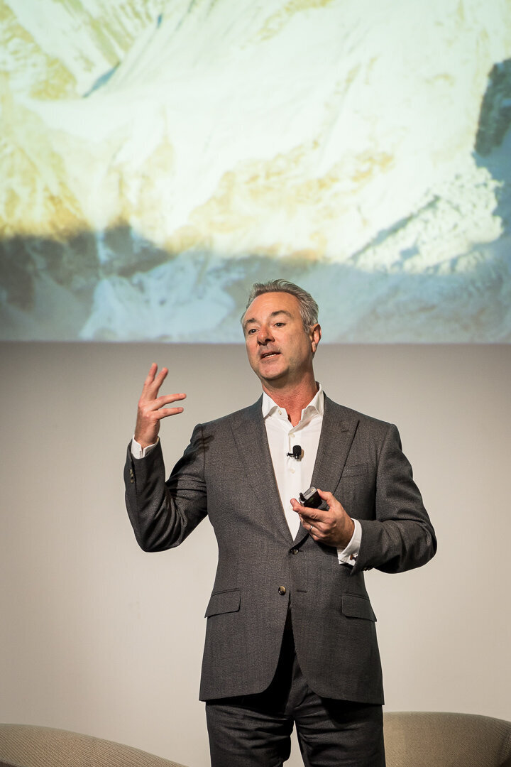 Corporate event photography of speaker presenting confidently with arms raised during keynote new jersey.