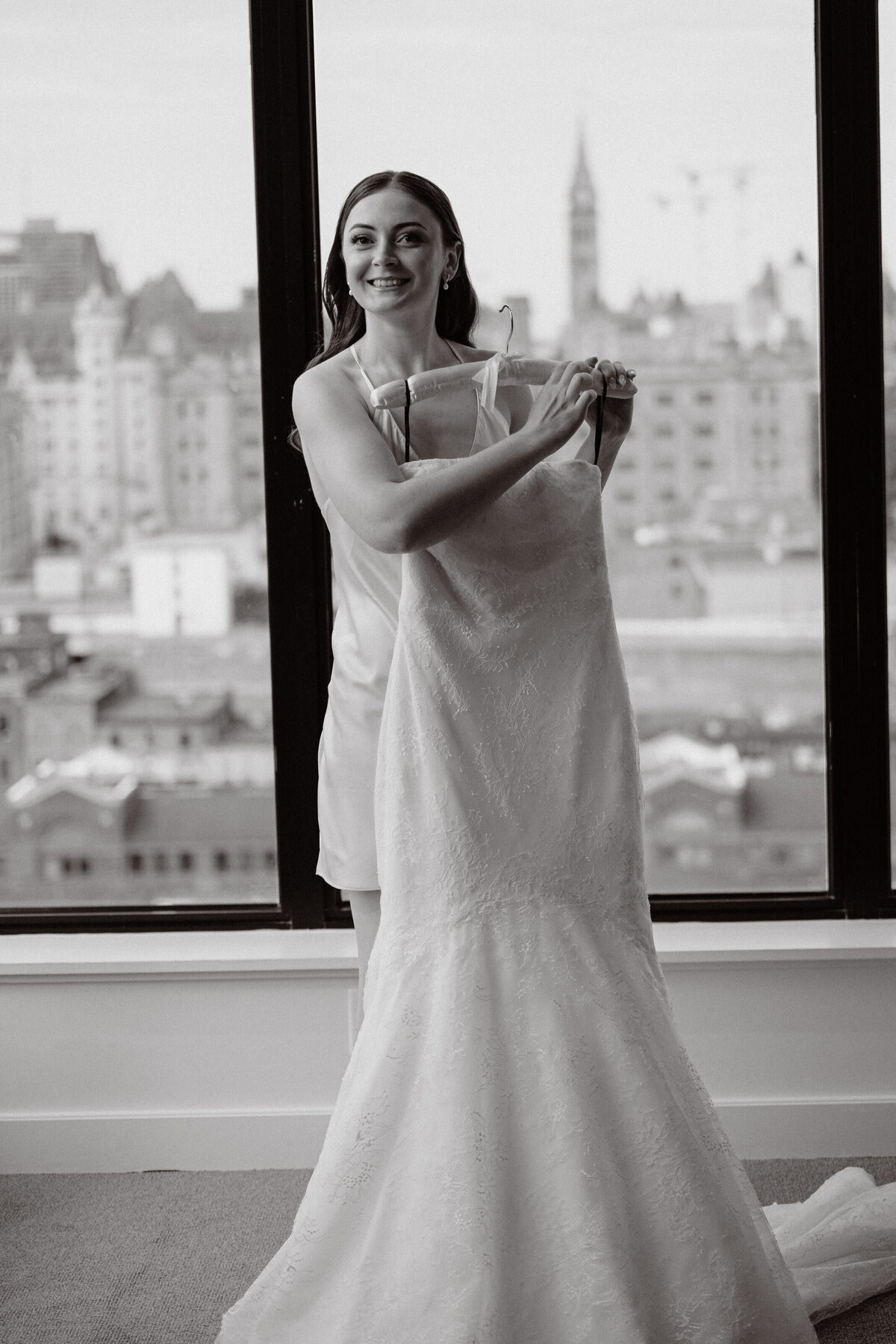 Bride holding her dress in excitement before she puts it on