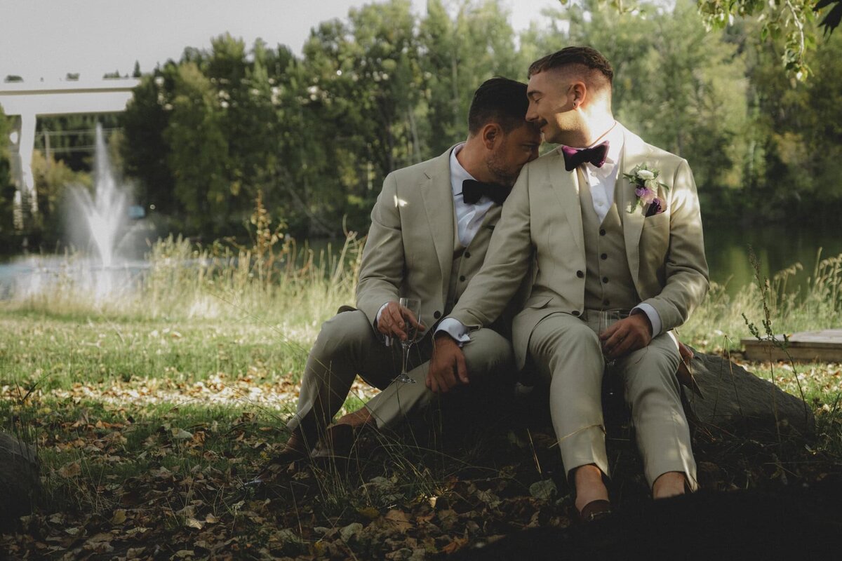 Gay wedding couple holding each other in city park in Calgary