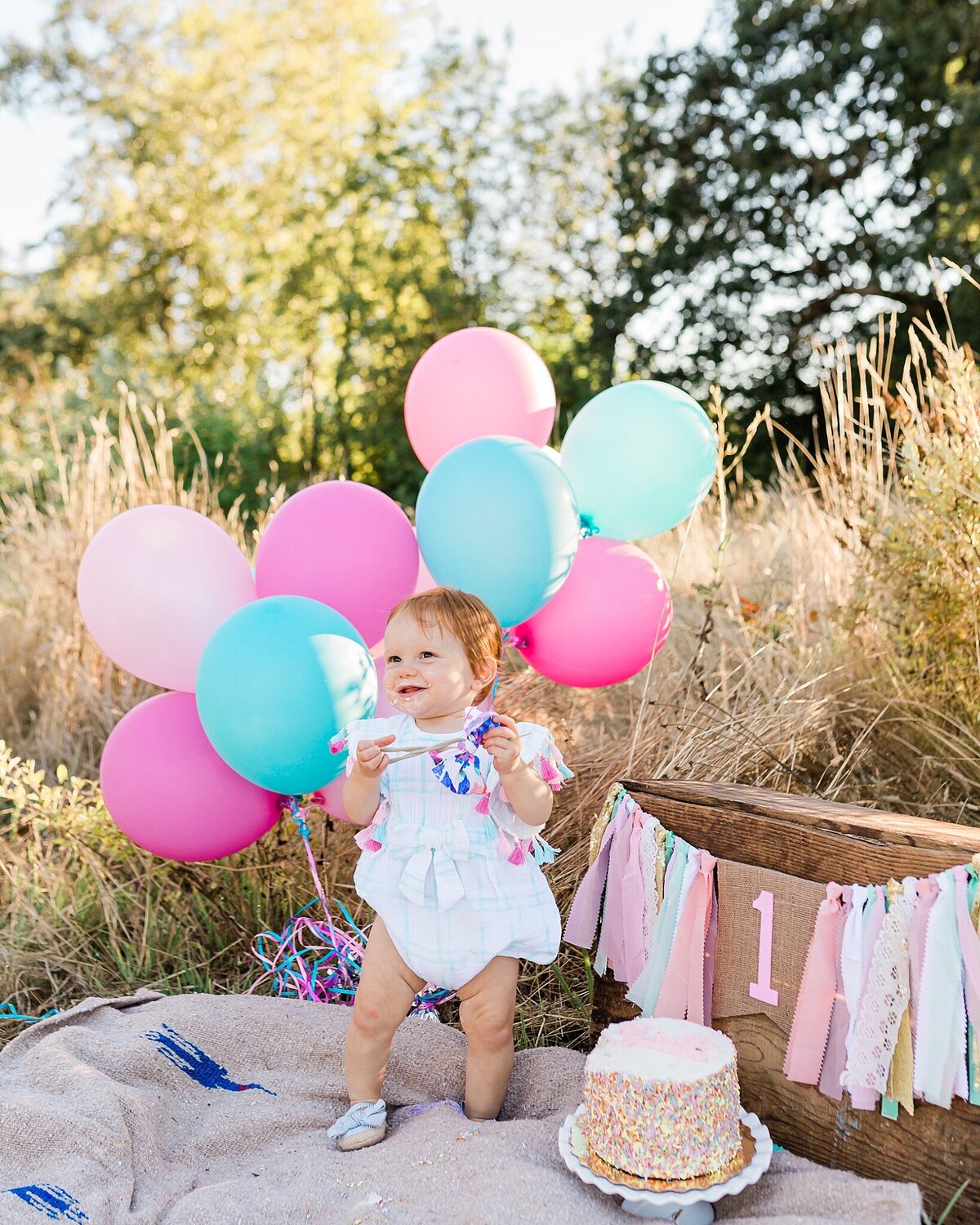 baby girl standing up for one year birthday pictures in hillsboro oregon
