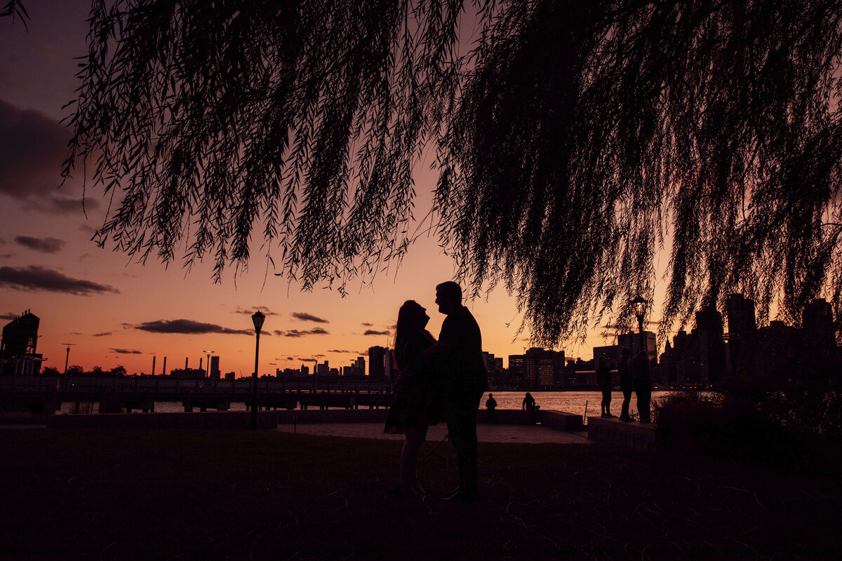 Couple in silhouette at sunset during engagement shoot on Long Island in Queens New York City