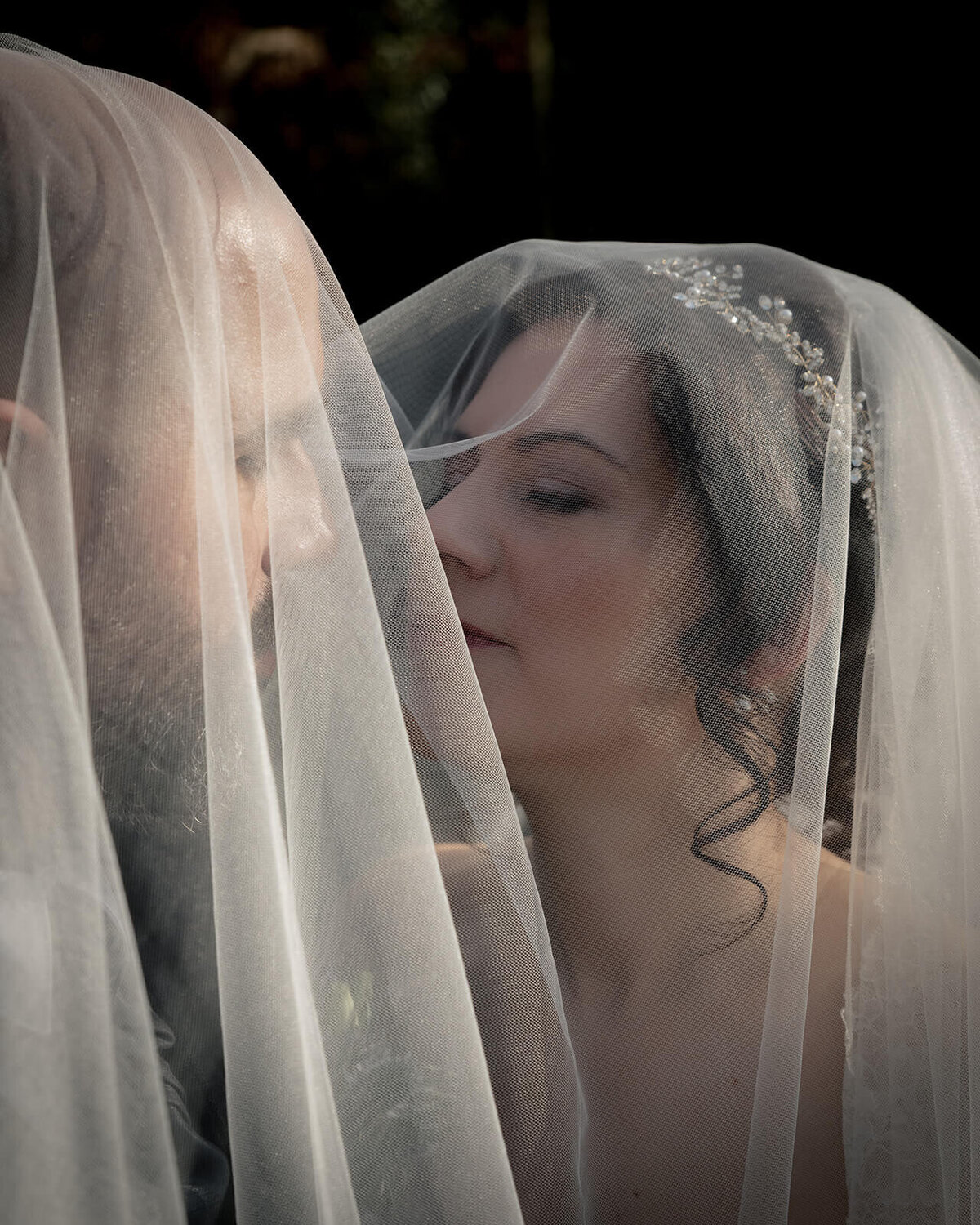 An American Bride and Groom kiss under the veil 