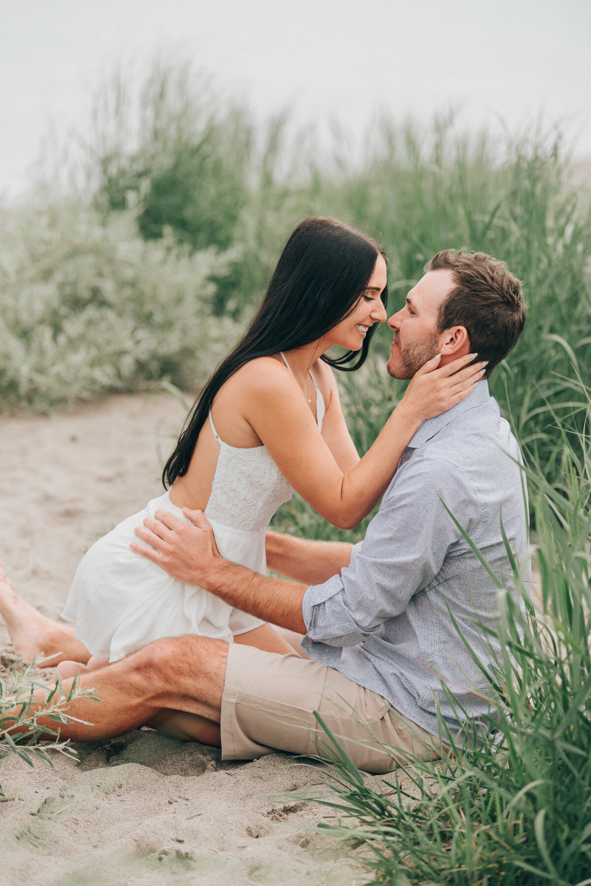 Couple posing on the beach for their summer engagement session