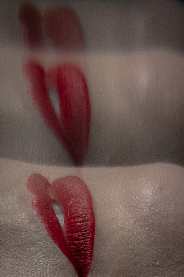 An image reflects a pair of red lips twice more in cinematic style
