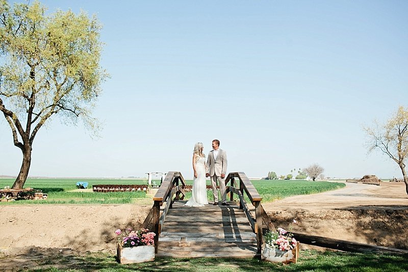 bride & groom standing on bridge