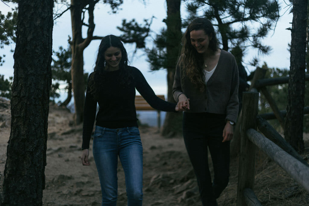 A couple holding hands and walking along a path.