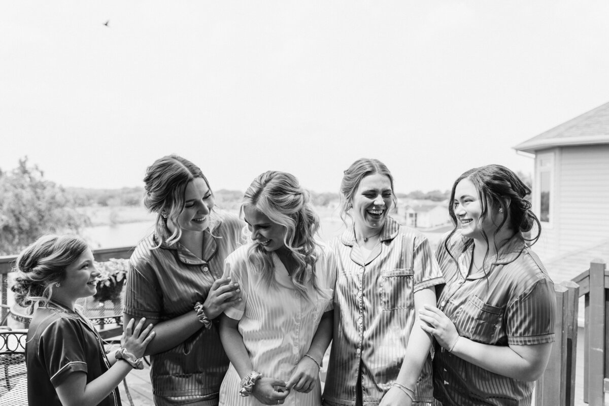 A bride and their wedding party laughing together
