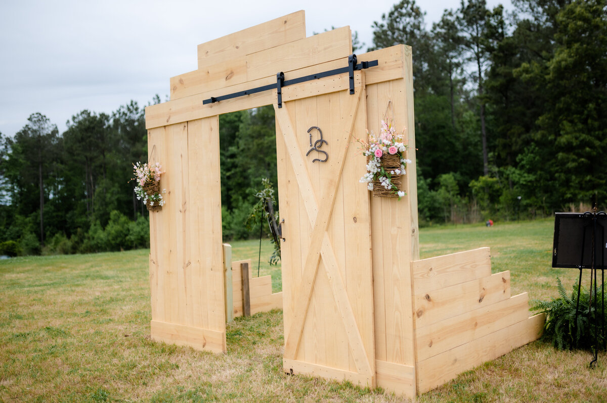 outdoor wedding entrance decor of barn doors leading into the ceremony space