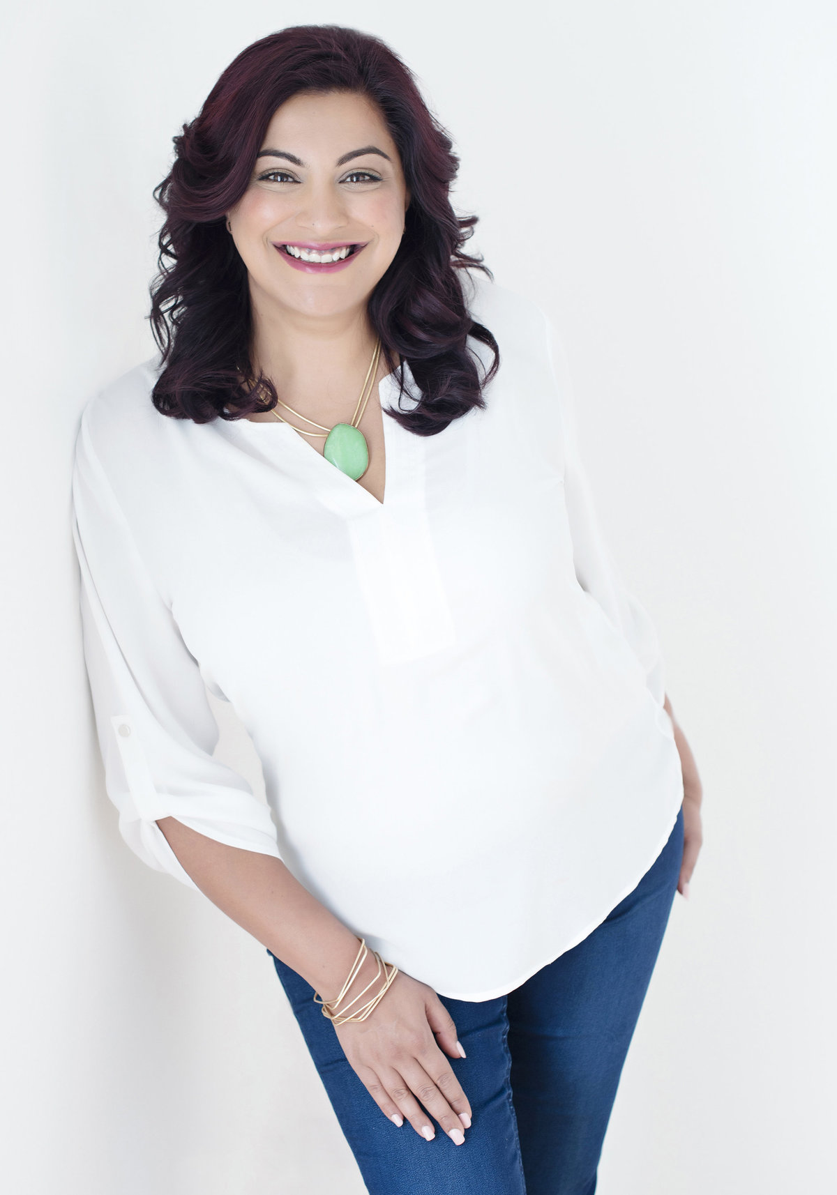 headshot of a powerful woman in white  shirt and  denim looking straight smiling  and charming beautiful strong and  powerful