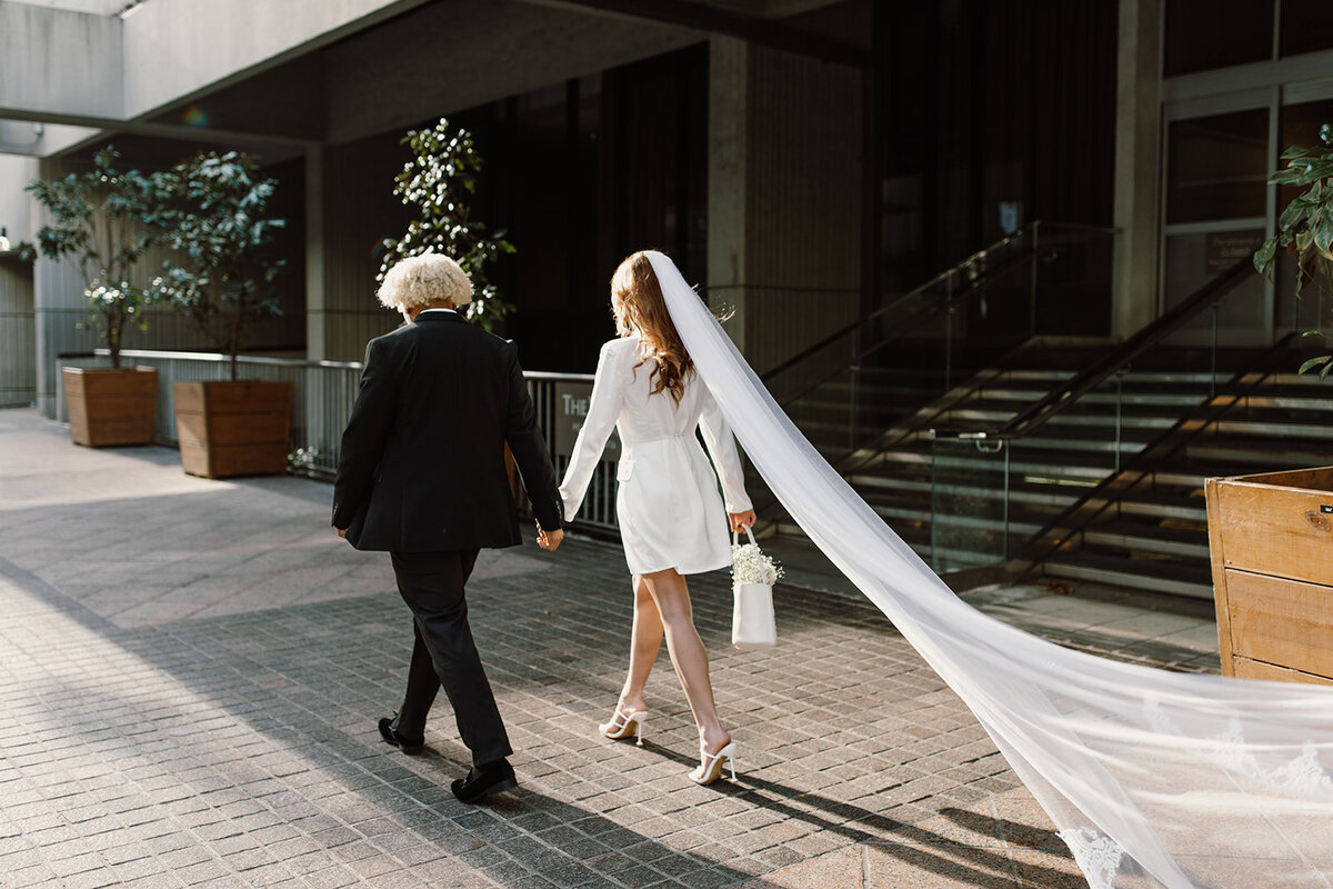 bride and groom walking together on sidewalk