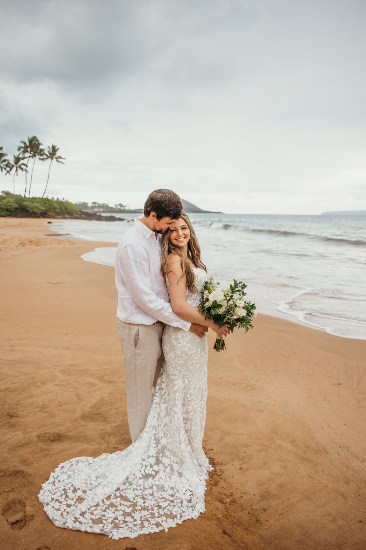 Maui Wedding Photographer captures groom hugging bride on beach after Maui beach wedding