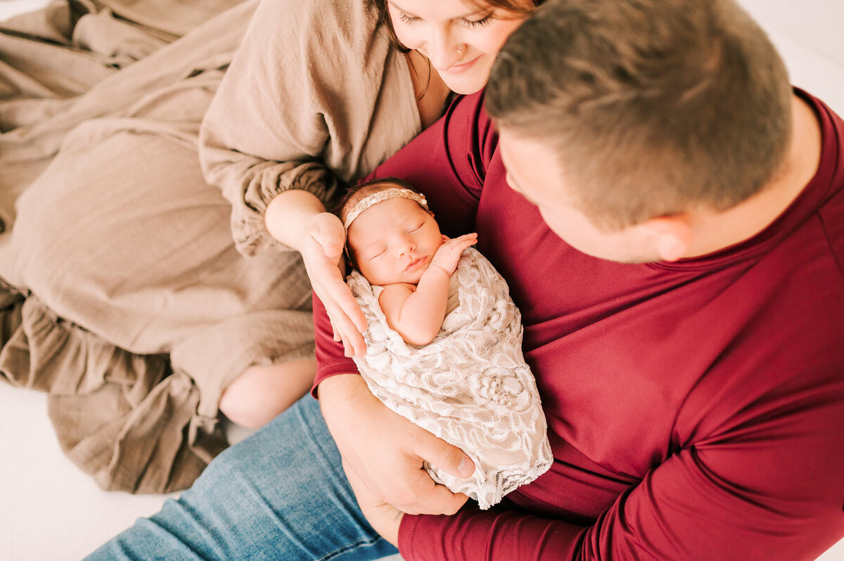 Springfield MO newborn photography of parents looking down on sleeping newborn baby girl