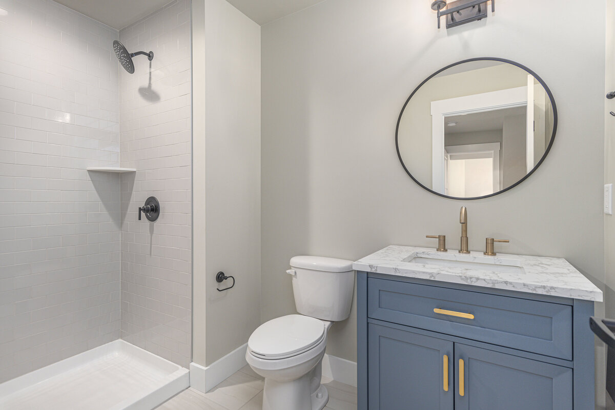 A bathroom with blue cabinets and a shower