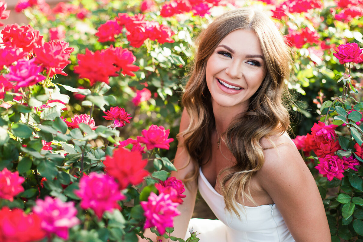 college senior girl smiling in flowers