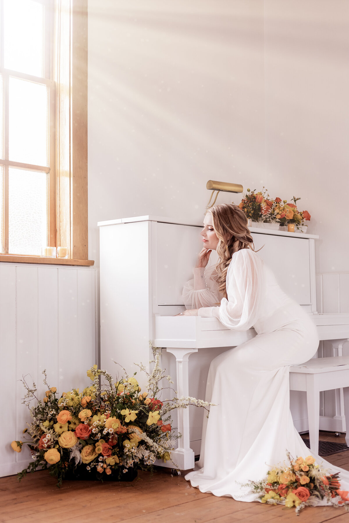 Bride sits at piano and stares out the window