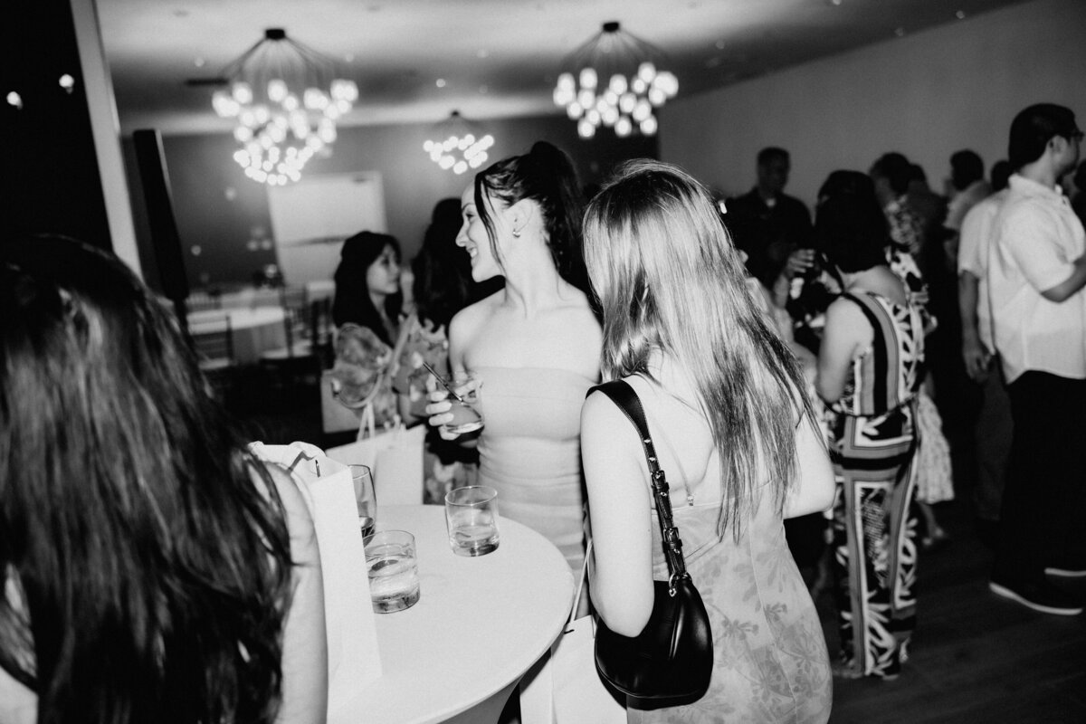 Black and white of guests mingling in the ballroom of The Deck Waikiki