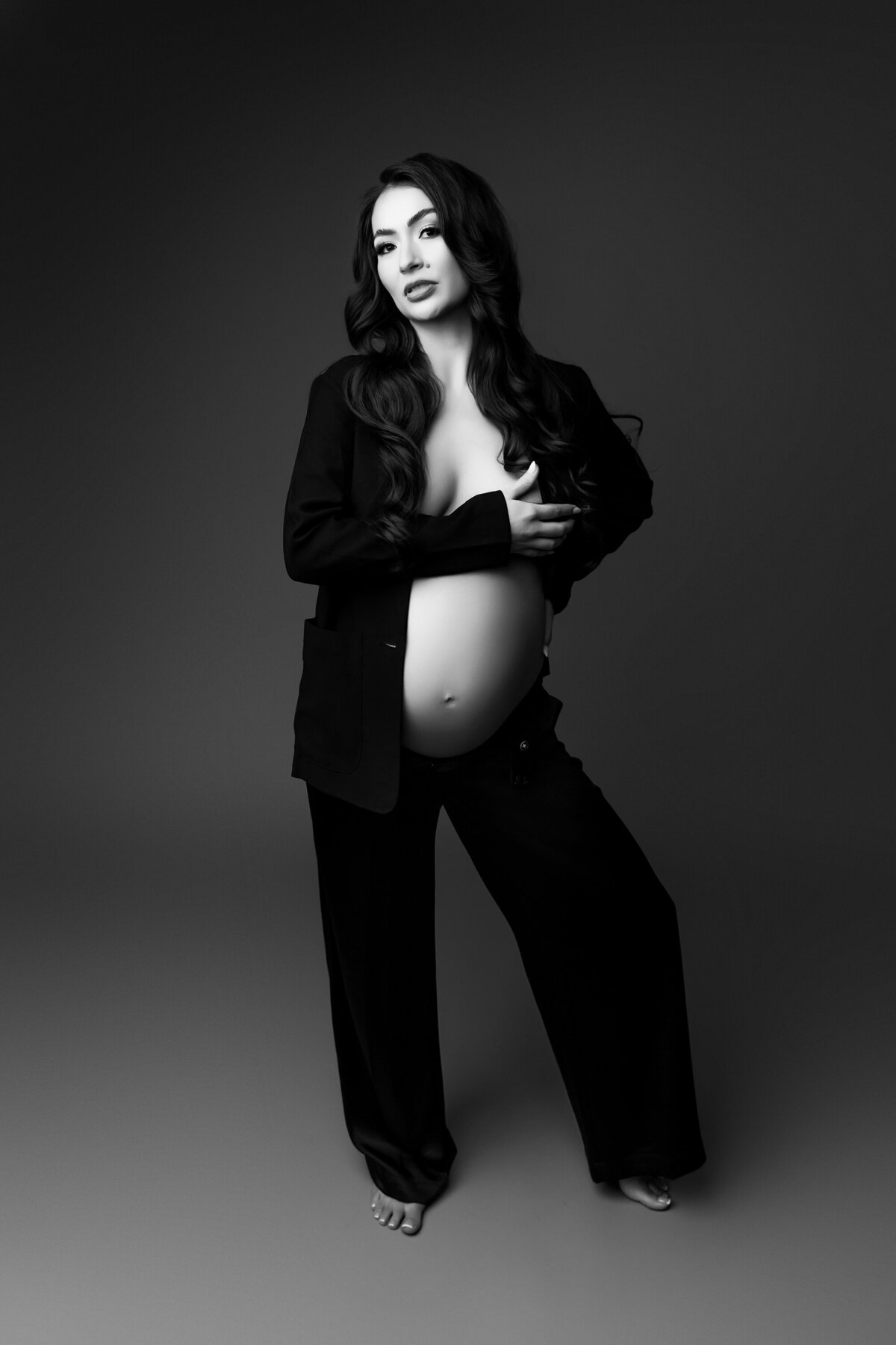 black and white picture of pregnant mom in blazer for her maternity session at phoenix studio