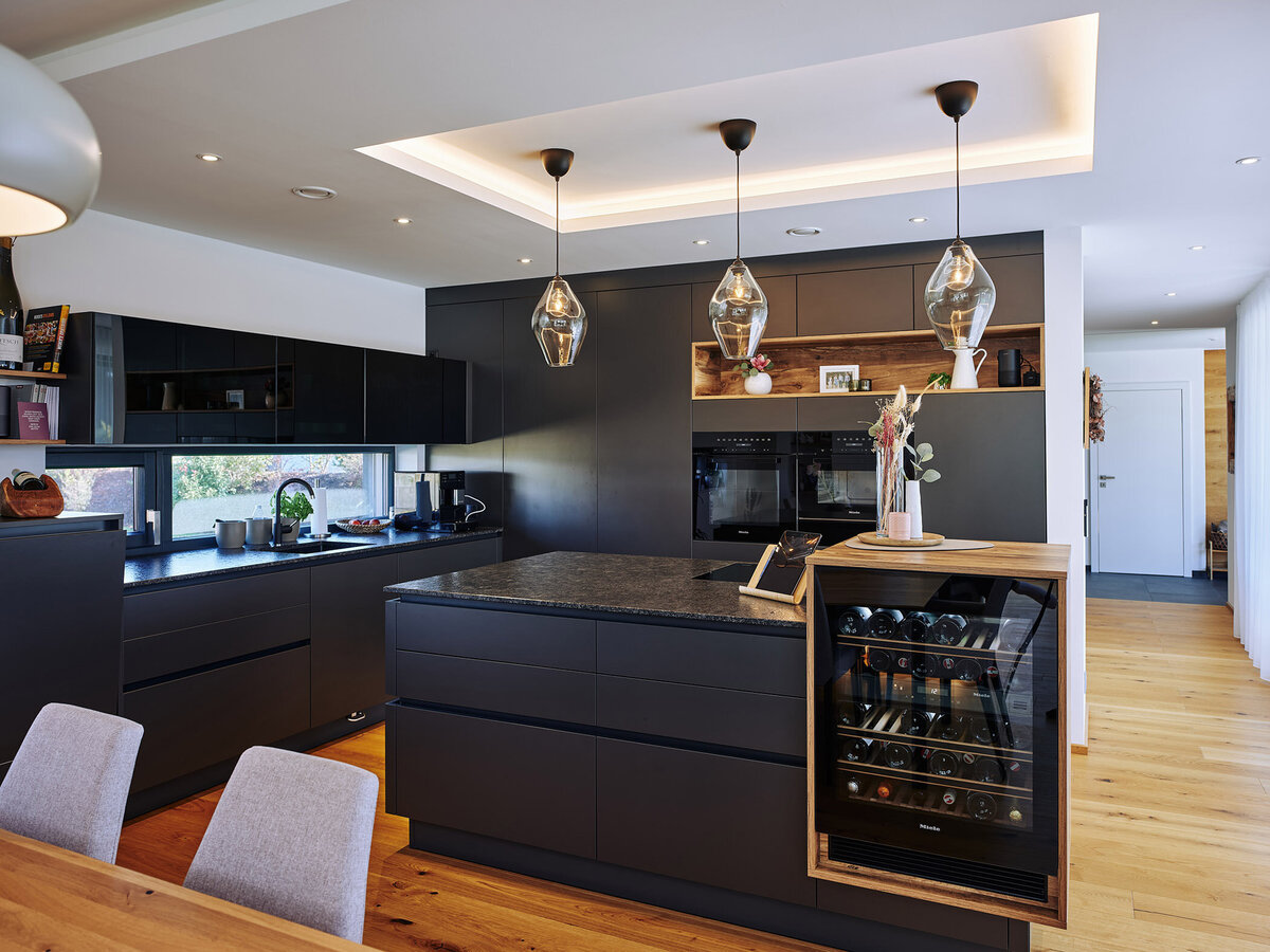 Interiorfotografie einer modernen Designküche mit Kochinsel, Weinkühlschrank und stimmungsvoller Beleuchtung – hochwertige Innenraumaufnahme für Architektur- und Wohnbauprojekte in Österreich