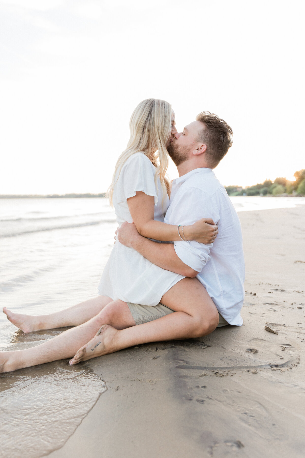 Couple kissing on the sand at the beach