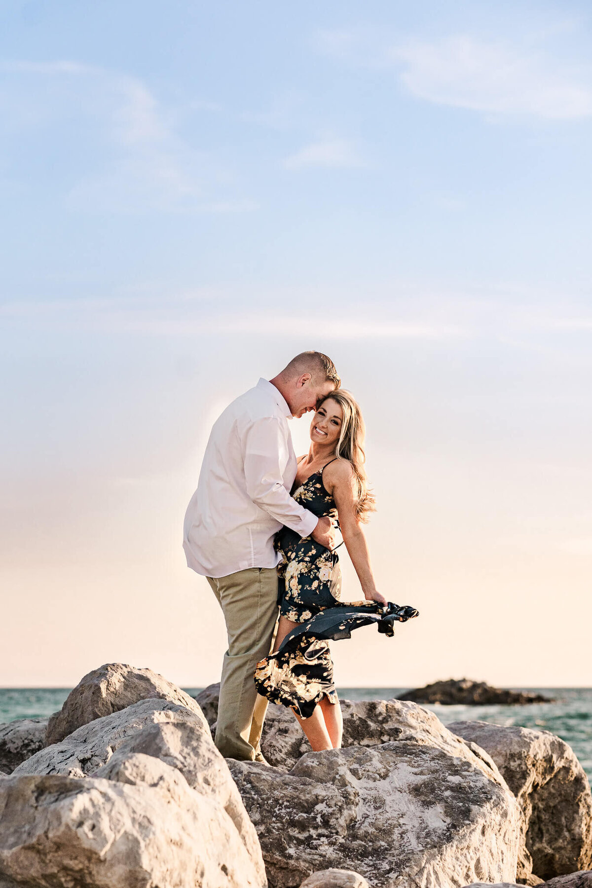 Orange-Beach-Alabama-Beach-Sexy-Intimate-Engagement-Photos-Wedding-Photographer-Videographer-Travis-Ralyn-Standing-On-Rocks-Sunset-Dramatic-Dress